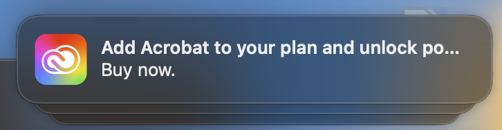 Screenshot of a Mac desktop push notification from Adobe soliciting the purchase of additional software. "Add Acrobat to your plan and unlock po... Buy now."